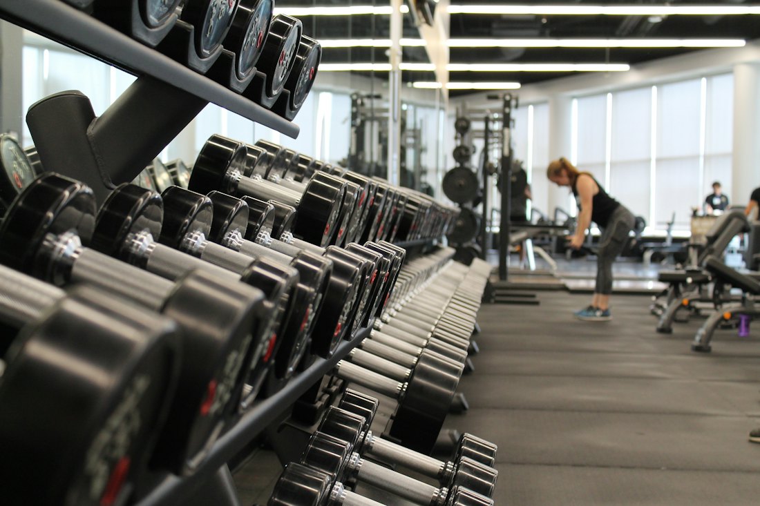 Racks of dumbbells lined along the gym wall