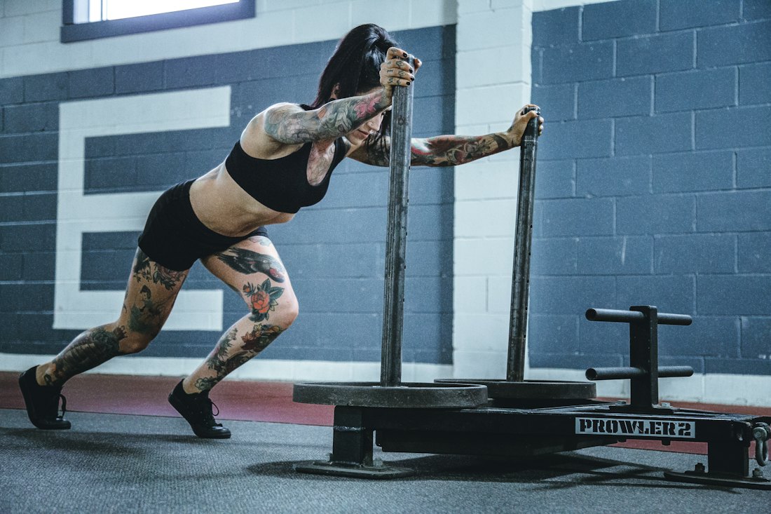 An athlete driving a barbell through a landmine